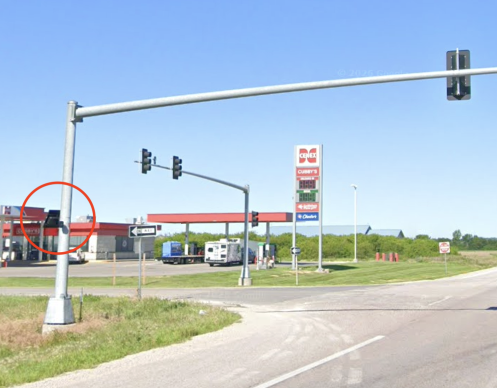 Signalized intersection with a galvanized traffic signal mast arm pole carrying the Flock camera
